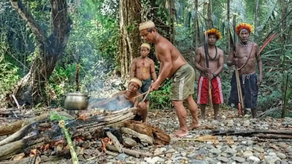 Indígenas de la selva cocinando sus alimentos en fuego después de cazar