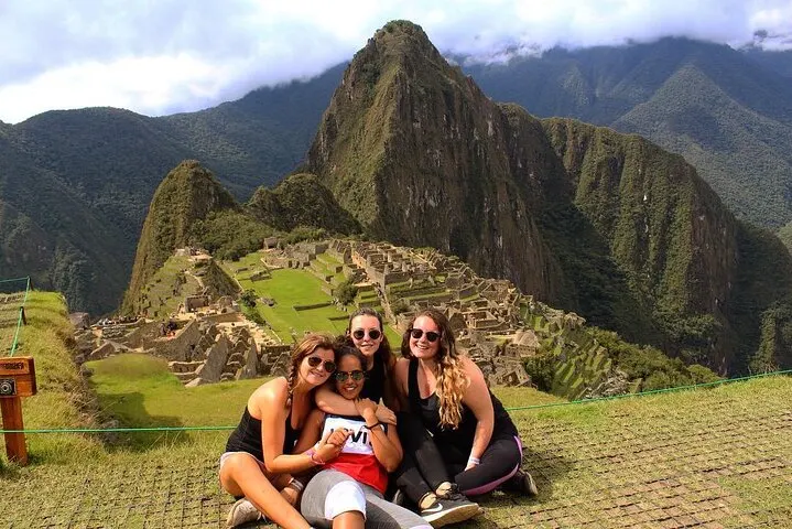Group of travelers taking photos at the iconic Machu Picchu viewpoint on the Circuit 2 route