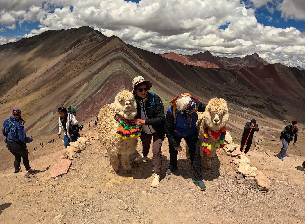 Clients at Rainbow Mountain with llamas at the classic viewpoint
